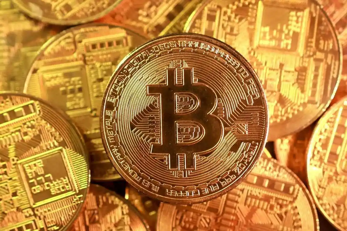 Close-up of multiple Bitcoin coins stacked together, representing the cryptocurrency market amid rising volatility and price drops