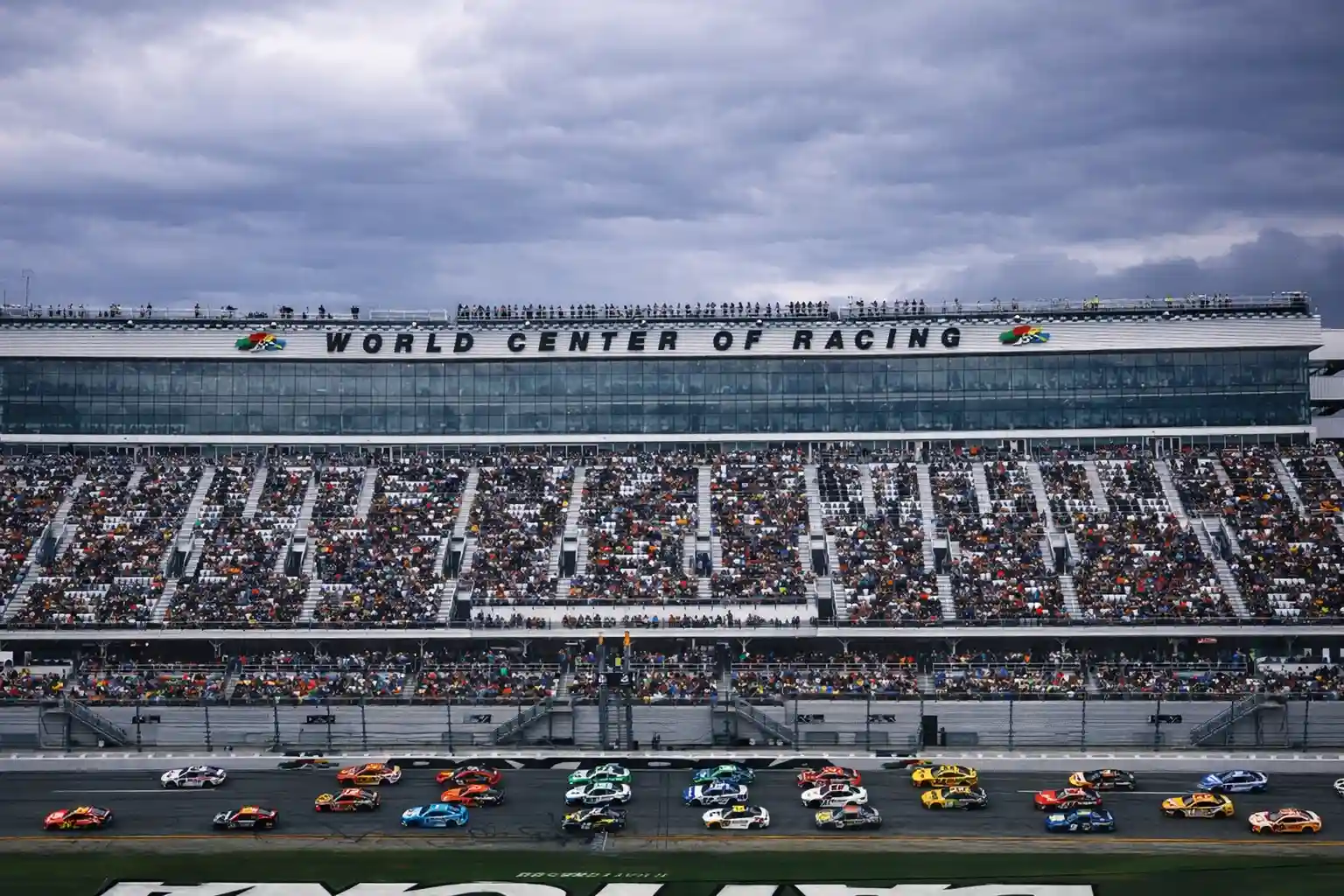 Packed grandstands at Daytona International Speedway as NASCAR cars compete during the Daytona 500.