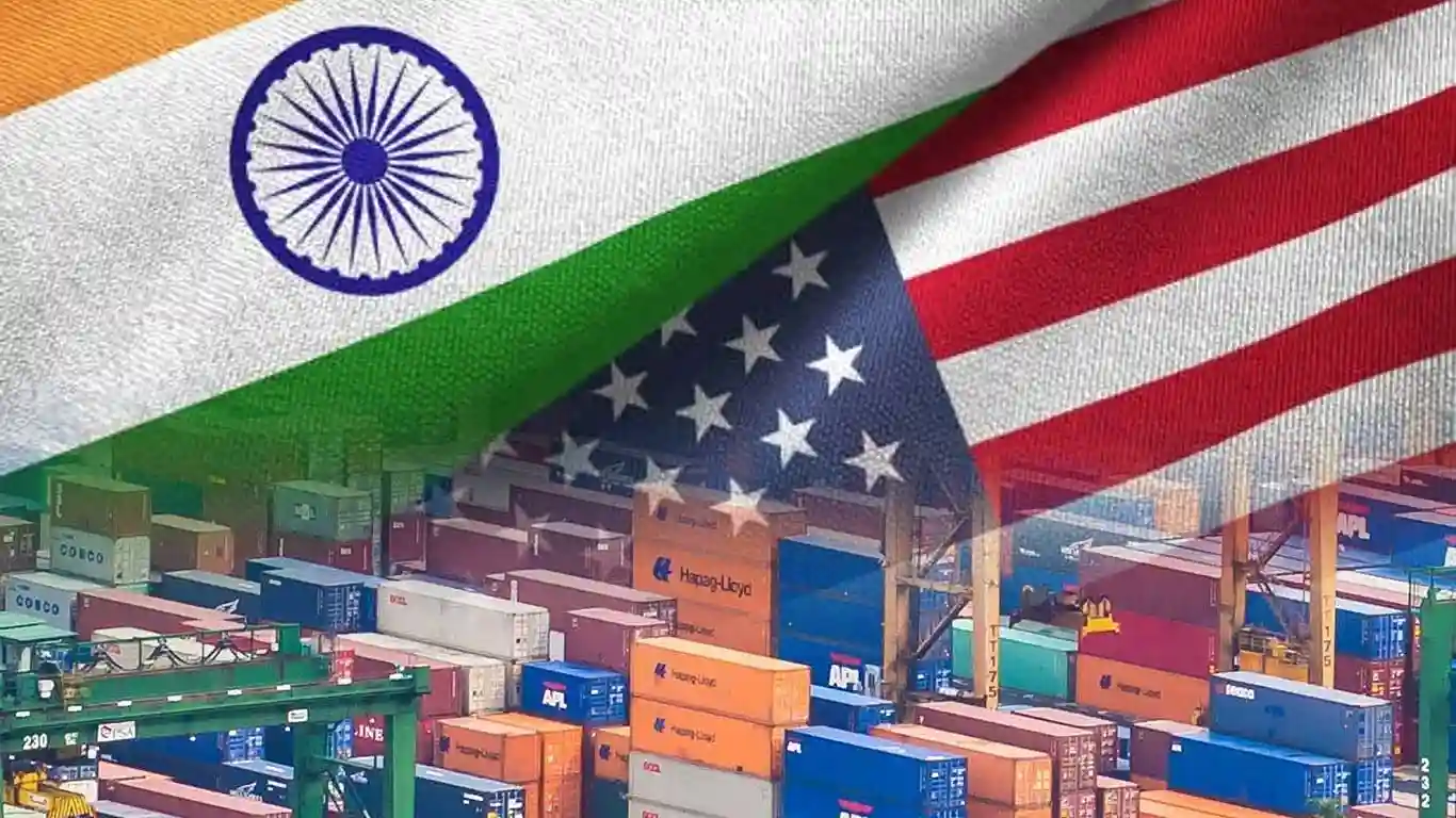 A close-up of the Indian and U.S. flags with a backdrop of shipping containers, symbolizing trade relations.