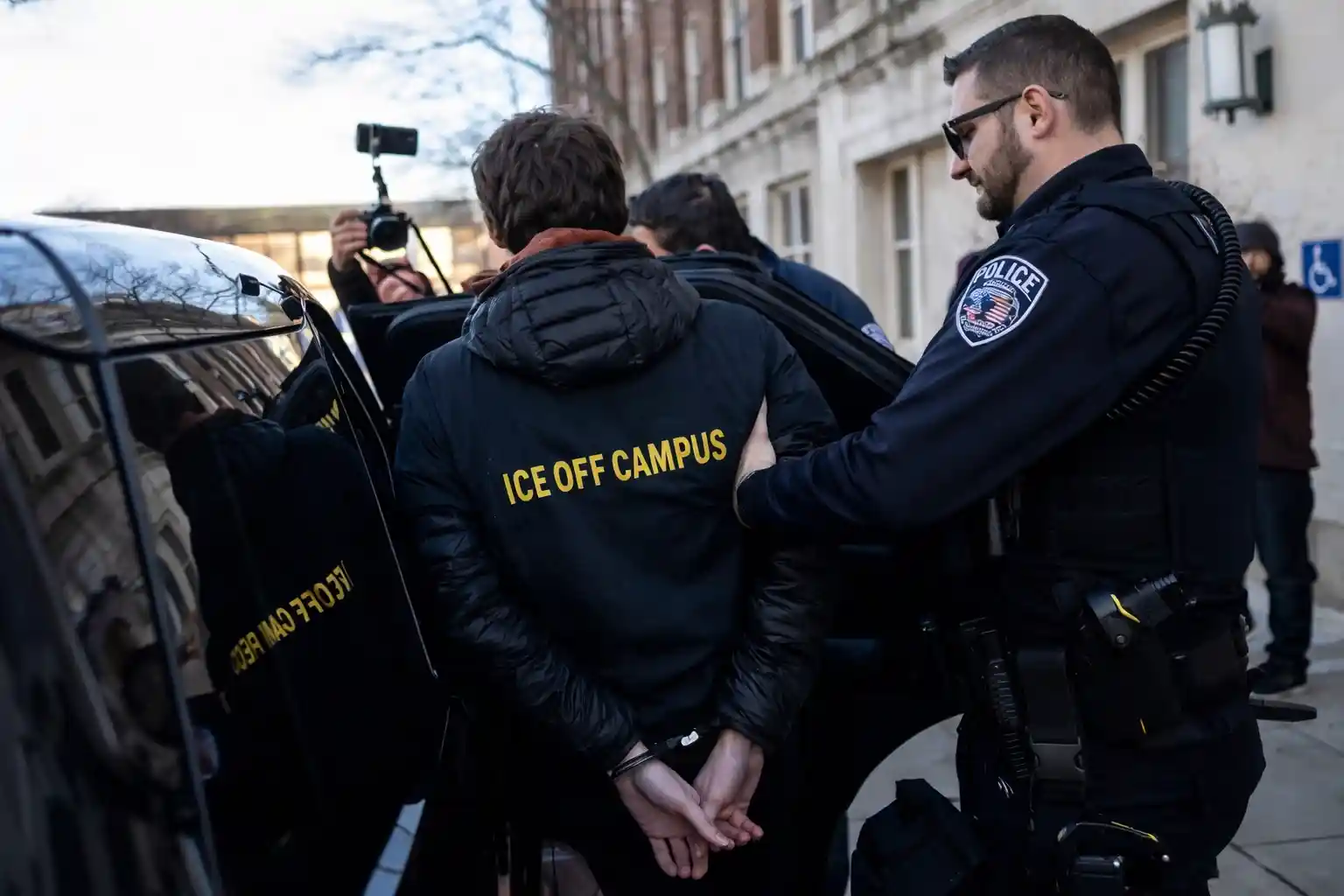 ICE agents arresting a suspect in Minneapolis with 'ICE OFF CAMPUS' on their jacket