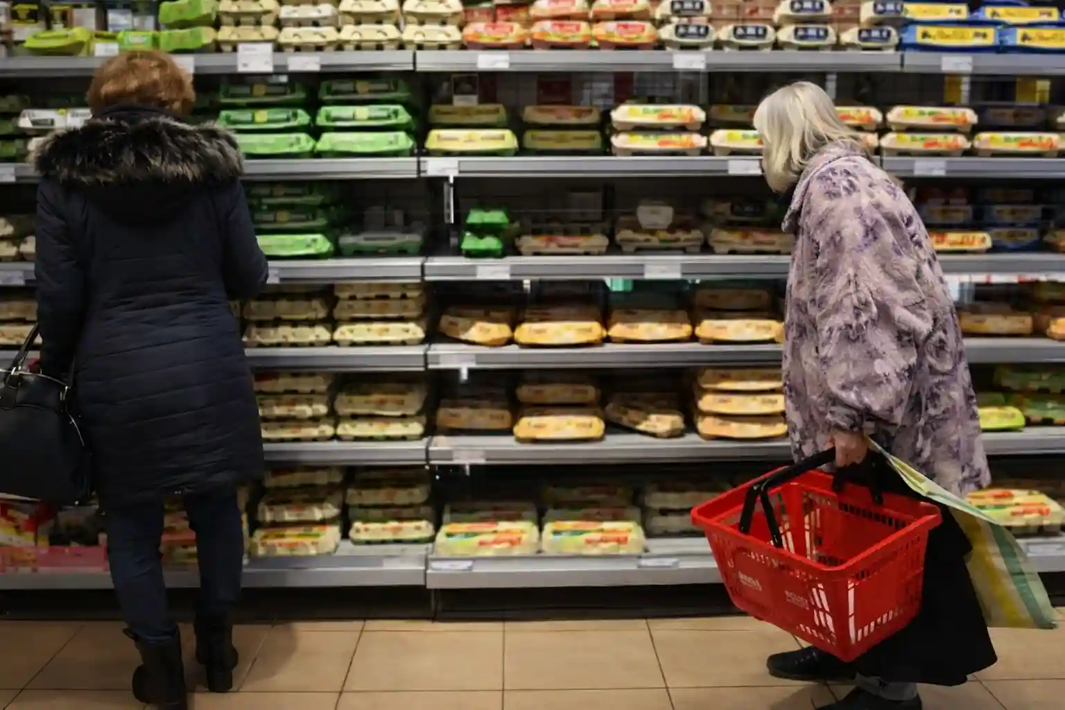 Shoppers browsing the egg section in a grocery store