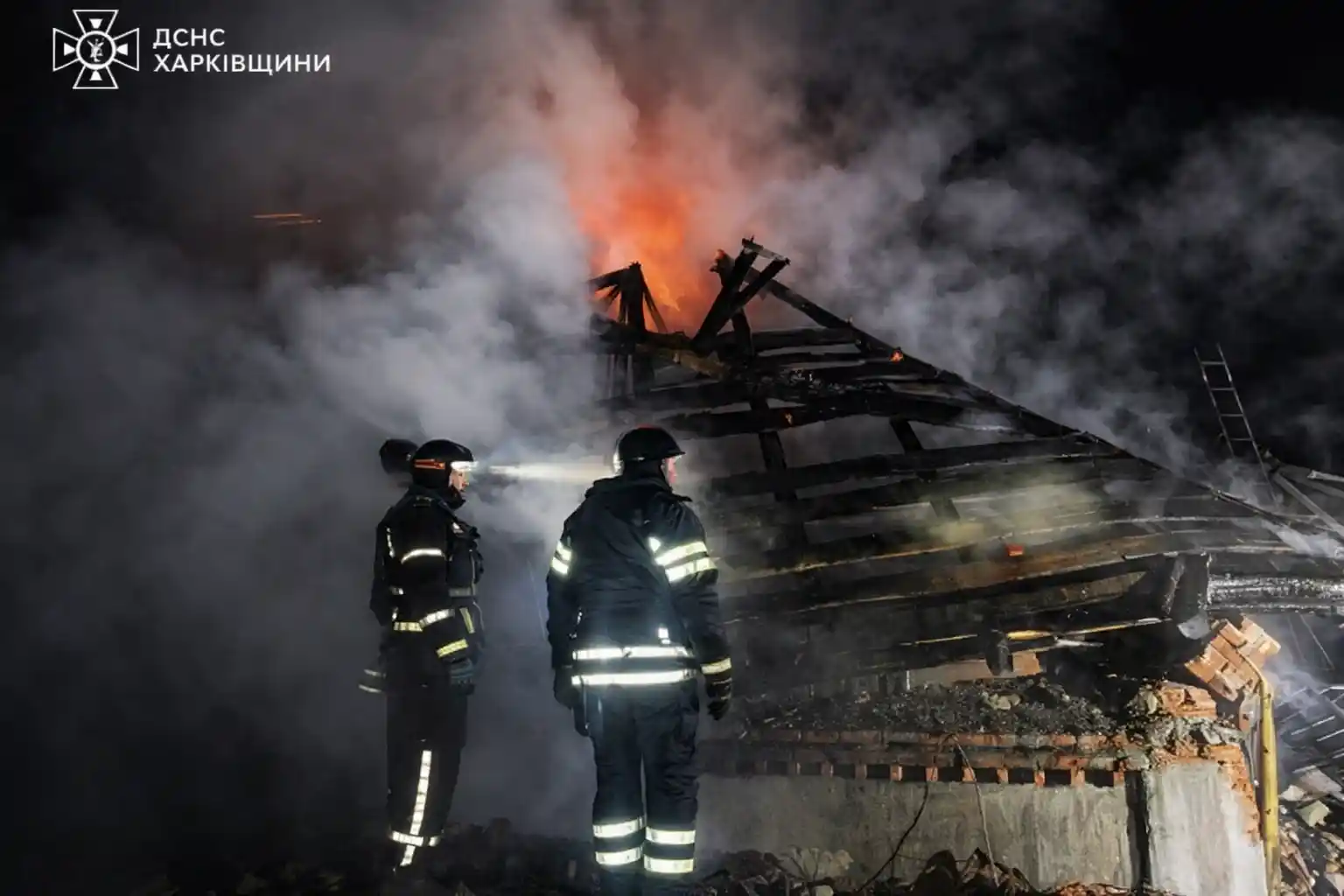 Firefighters working through smoke and debris at the scene of a deadly drone attack in Bohodukhiv, Ukraine.