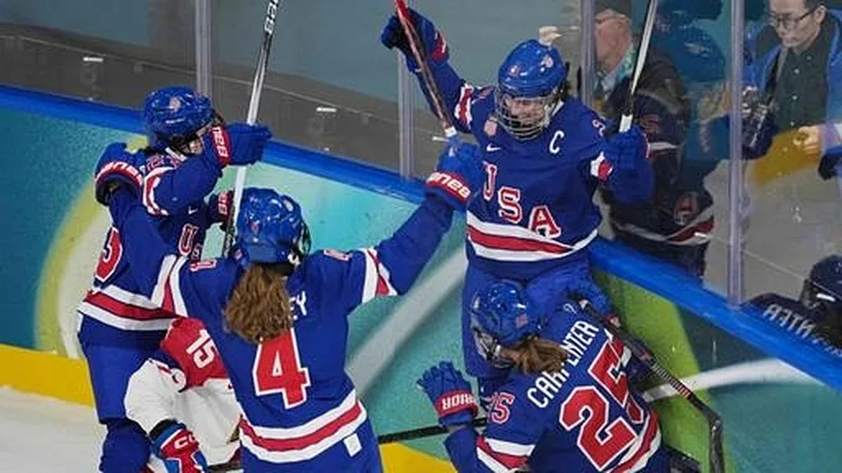 U.S. women’s ice hockey players celebrate along the boards after scoring against Czechia at the Milano Cortina 2026 Winter Olympics